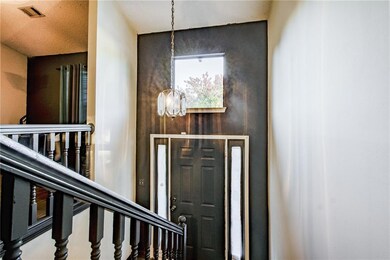 Foyer entrance featuring a chandelier and stairway