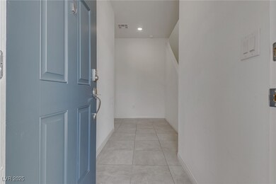 Hall with light tile patterned floors, recessed li