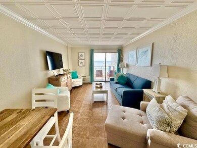 Living area featuring an ornate ceiling, tile patterned floors, a textured wall, and ornamental molding