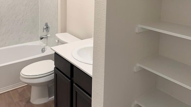 Full bathroom featuring hardwood / wood-style floors, toilet, shower / bathing tub combination, and vanity