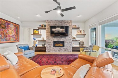 Living area with ceiling fan, a brick fireplace, wood finished floors, and recessed lighting