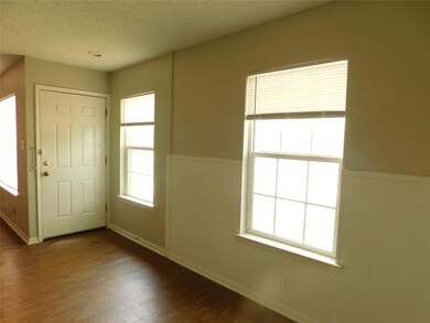 Foyer with baseboards, wood finished floors, and 
