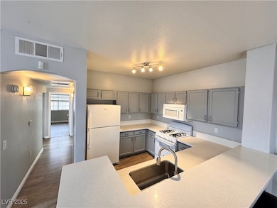 Kitchen with visible vents, gray cabinets, a sink,