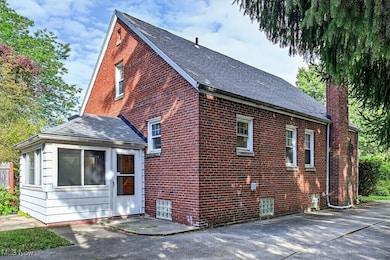 View of home's exterior featuring a chimney, brick siding, and roof with shingles