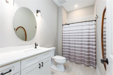 Bathroom featuring vanity, a shower with shower curtain, light tile patterned floors, and recessed lighting