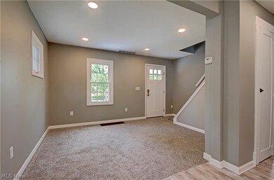 Foyer featuring light carpet