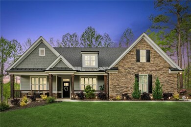 Craftsman-style home featuring stone siding, a standing seam roof, roof with shingles, a front lawn, and a porch