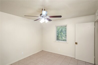 Spare room featuring a ceiling fan, light tile pat