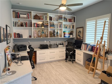 Office with a ceiling fan, built in desk, and ligh