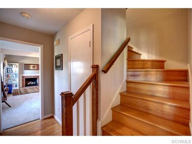 Entry way with curved, wood stairway and coat clos