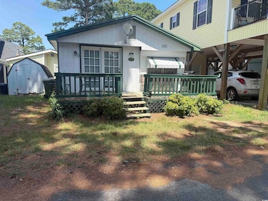 View of front of property featuring a storage shed and a deck