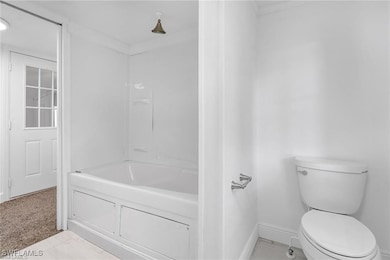 Bathroom with toilet and baseboards