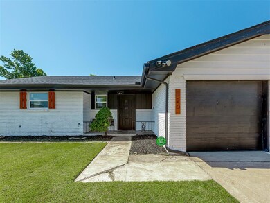 Ranch-style house featuring brick siding, a garage, concrete driveway, a front yard, and a shingled roof