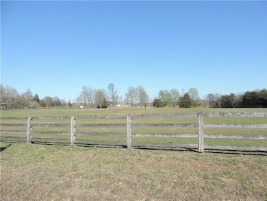 Driving down the drive, view of level pasture and barn in distance.