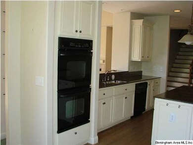 Double oven in kitchen, which has custom cabinets,
