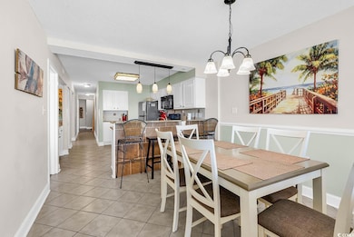 Dining room with light tile patterned flooring, a chandelier, and a textured ceiling