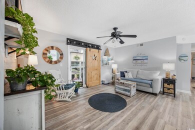 Living room featuring a barn door, a textured ceil