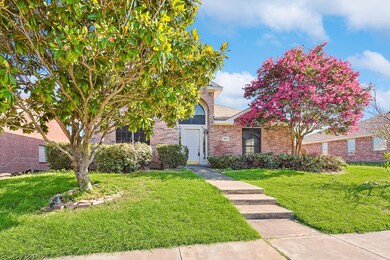 View of property hidden behind natural elements featuring a front lawn