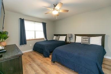 Bedroom with light wood finished floors, baseboar