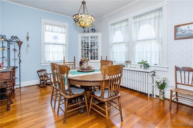 Dining room with a chandelier, light hardwood / wo