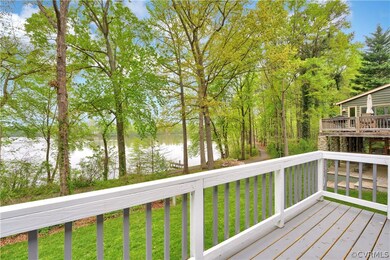 Wooden terrace with a water view and a lawn