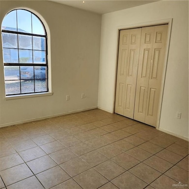 Unfurnished bedroom with light tile patterned floors and a closet