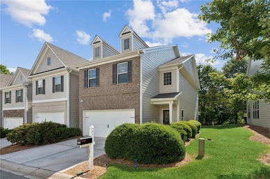 View of front of home featuring a garage, concrete driveway, a front yard, and brick siding