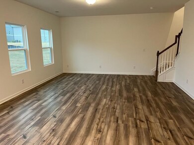 Empty room featuring dark wood-style floors and stairs