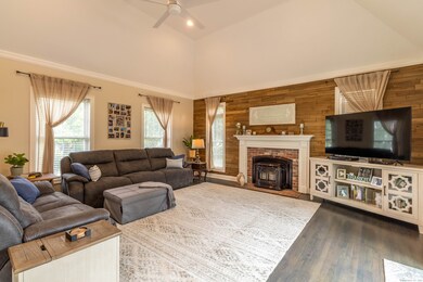 Family room with tray ceiling and pellet stove fireplace.