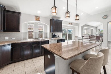Kitchen with arched walkways, a sink, vaulted cei