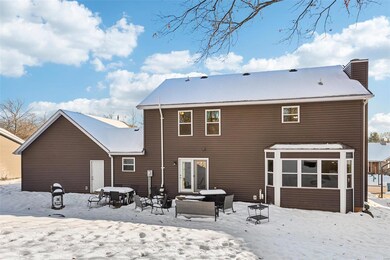 Snow covered rear of property with an outdoor hangout area