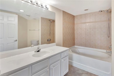 Full bathroom featuring tile patterned flooring, vanity, toilet, and tiled shower / bath