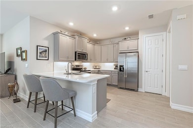 Kitchen featuring grey cabinets, Stainless Steel appliances, & quartz countertops