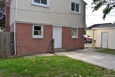 Rear view of property with brick siding and an outbuilding