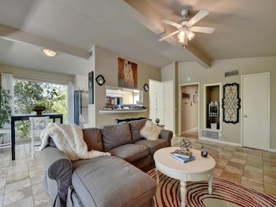 Living area featuring ceiling fan and light tile 