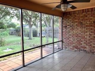 Unfurnished sunroom featuring a ceiling fan
