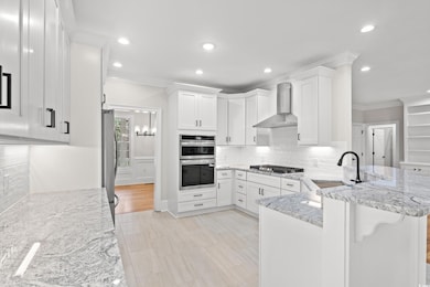Kitchen with wall chimney range hood, crown moldin