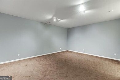 Carpeted spare room featuring baseboards