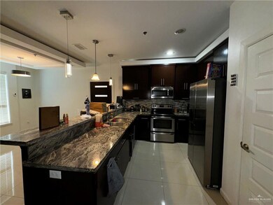 Kitchen featuring tasteful backsplash, stainless steel appliances, decorative light fixtures, sink, and ornamental molding