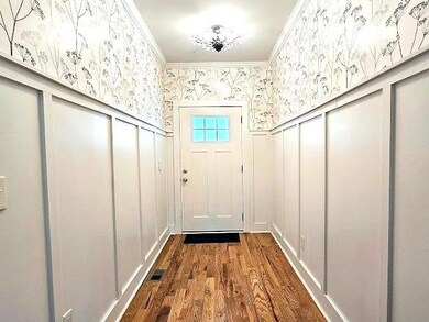 Doorway with crown molding and dark hardwood / wood-style flooring