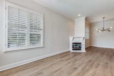 Unfurnished living room featuring a tile fireplace, crown molding, light wood-style flooring, a chandelier, and recessed lighting