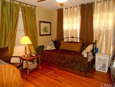 Second bedroom with hardwood floors and ceiling fa