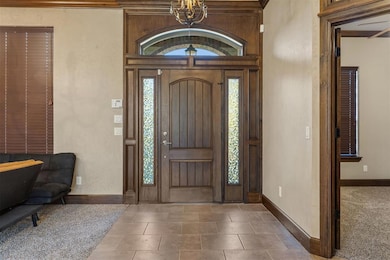 Entryway with a chandelier and baseboards