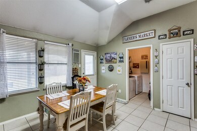 Tiled dining area featuring independent washer and
