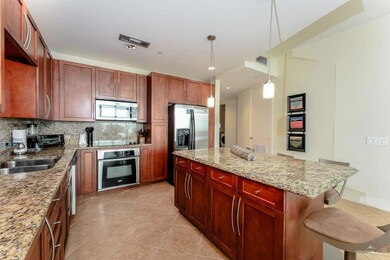Kitchen with tasteful backsplash, light tile patterned floors, a sink, and stainless steel appliances
