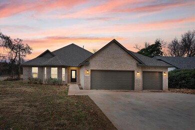 View of front of house with a garage, brick siding, concrete driveway, and roof with shingles