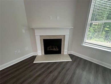Detailed view of wood finished floors, a high end fireplace, and baseboards