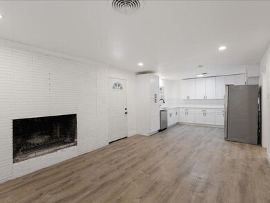 Unfurnished living room featuring a fireplace, light hardwood / wood-style floors, and sink