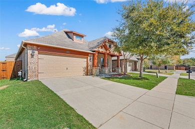 View of front of house featuring driveway, covered porch, roof with shingles, brick siding, and an attached garage
