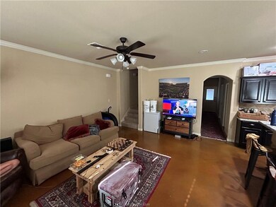 Living room with stairway, baseboards, arched walk
